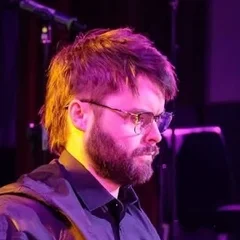 Alex playing bass guitar on stage